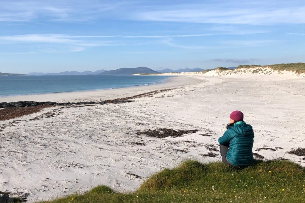 woman sitting on hill overlooking Berneray west beach
