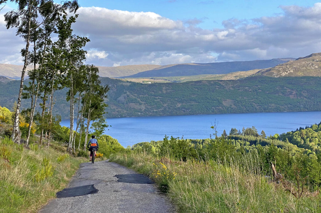 woman cycling down a hill on the great glen way cycle route
